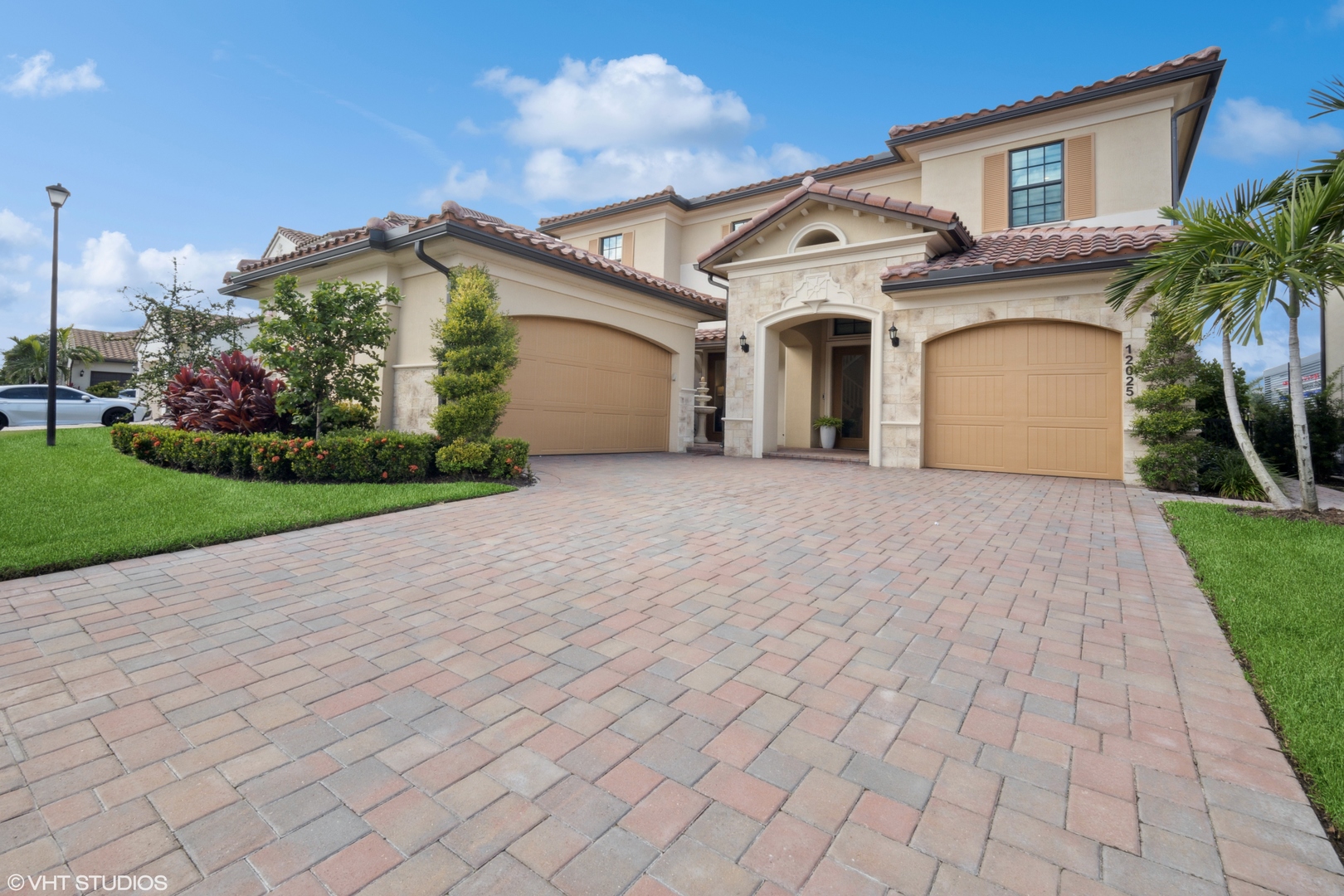 a front view of a house with a garden and garage