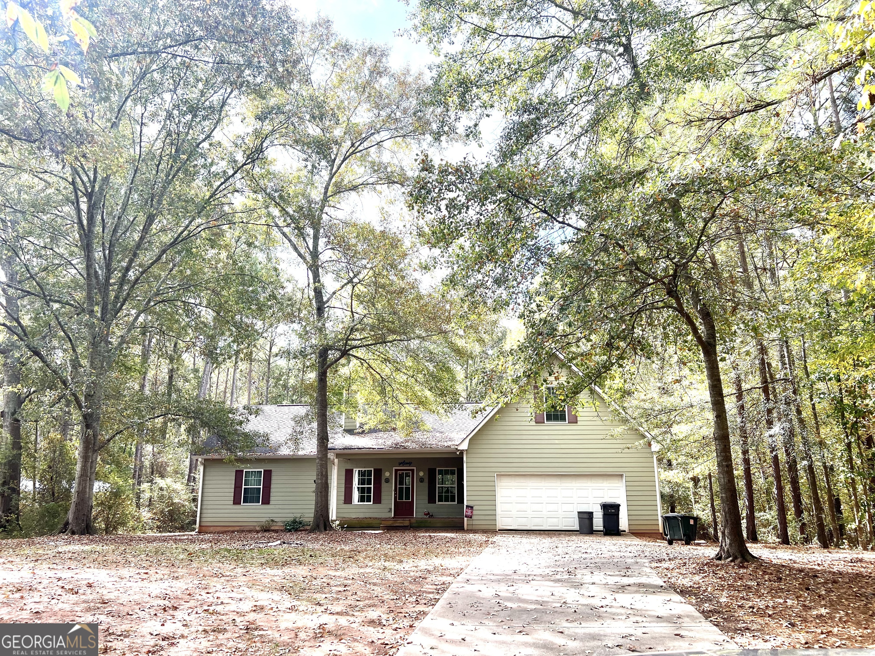 a front view of a house with a garden and trees