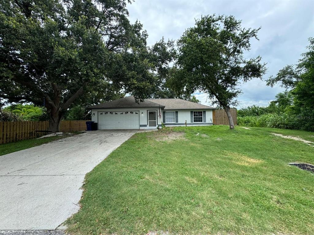 a front view of a house with a yard and a tree