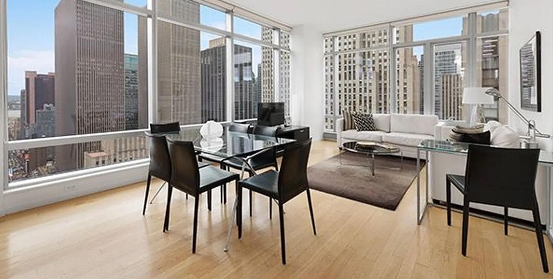 a dining room with furniture large windows and wooden floor