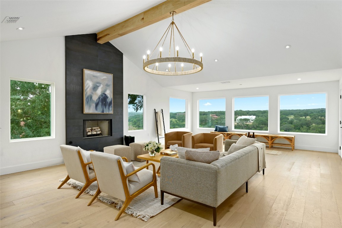 a living room with fireplace furniture and a large window