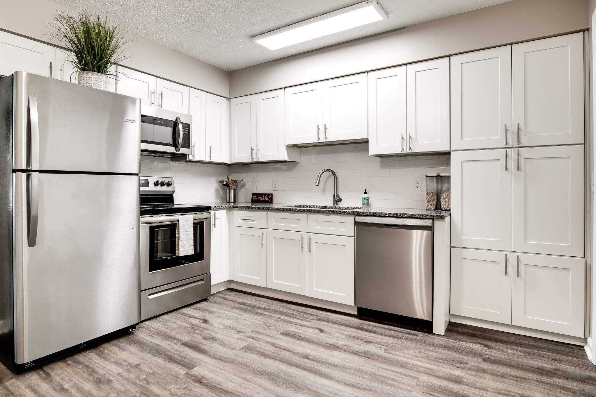 a kitchen with white cabinets and white appliances