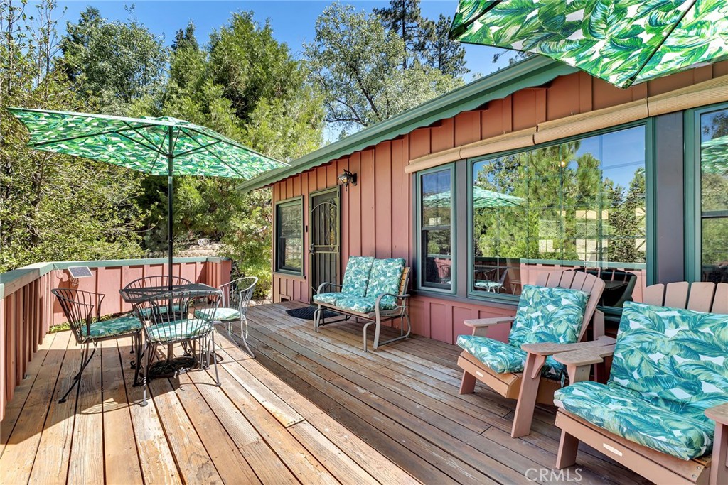 a patio with wooden floor table and chairs