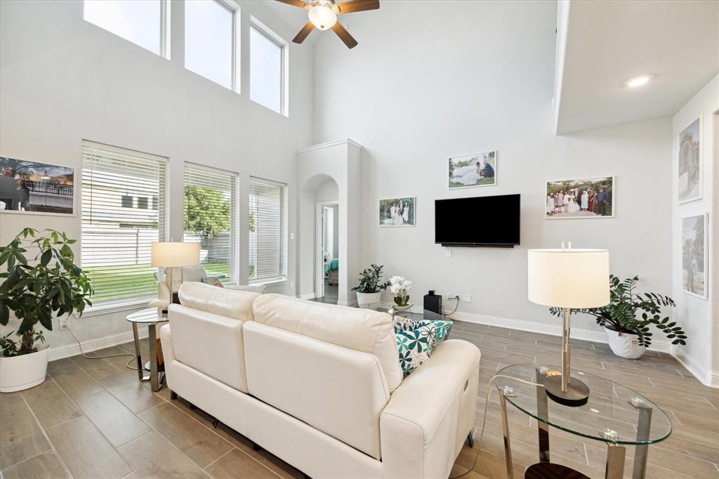 a living room with furniture a flat screen tv and a potted plant