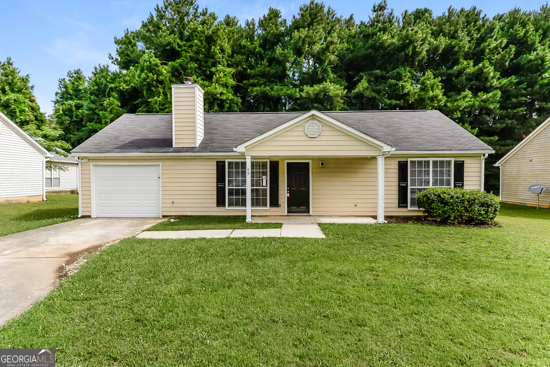 a front view of a house with a yard and trees