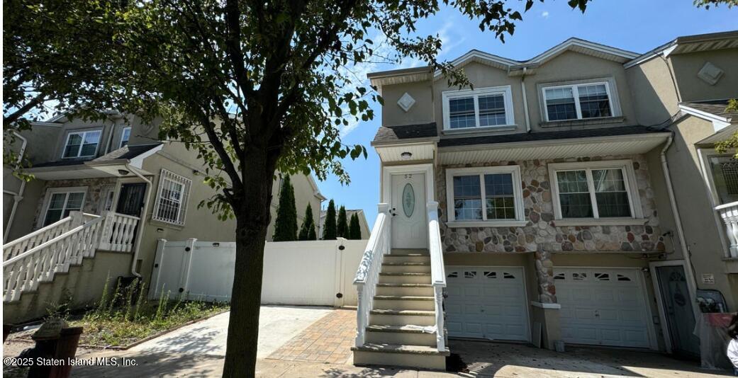 a front view of a house with a tree