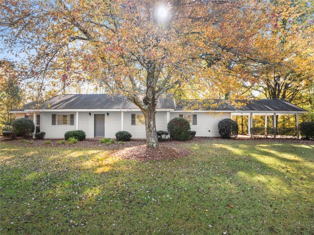 a front view of a house with a garden and trees