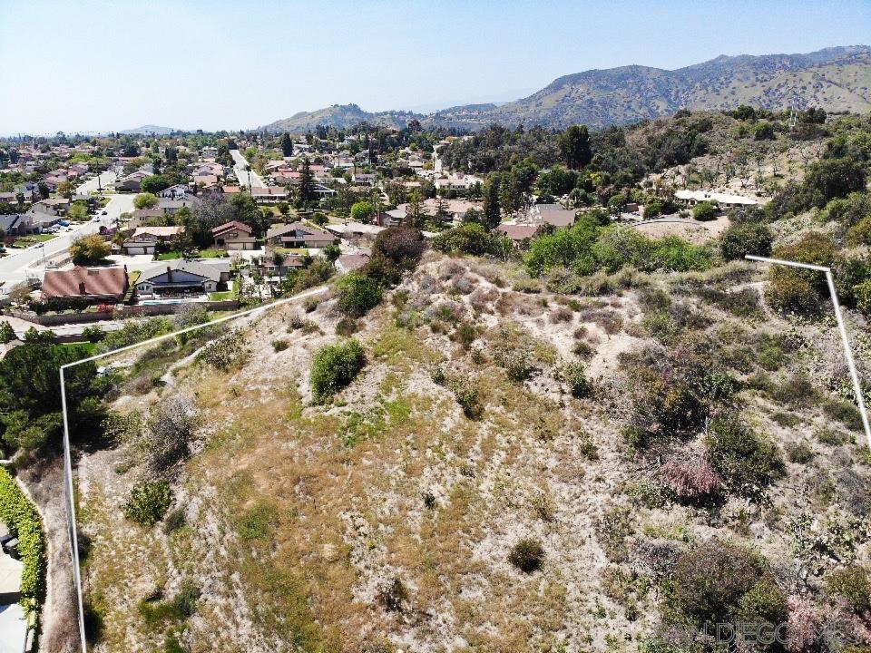 an aerial view of residential houses with outdoor space and trees