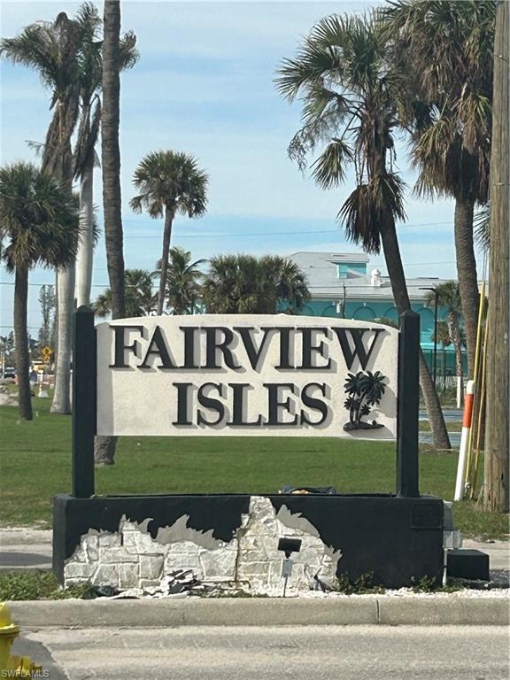 Community / neighborhood sign featuring a yard