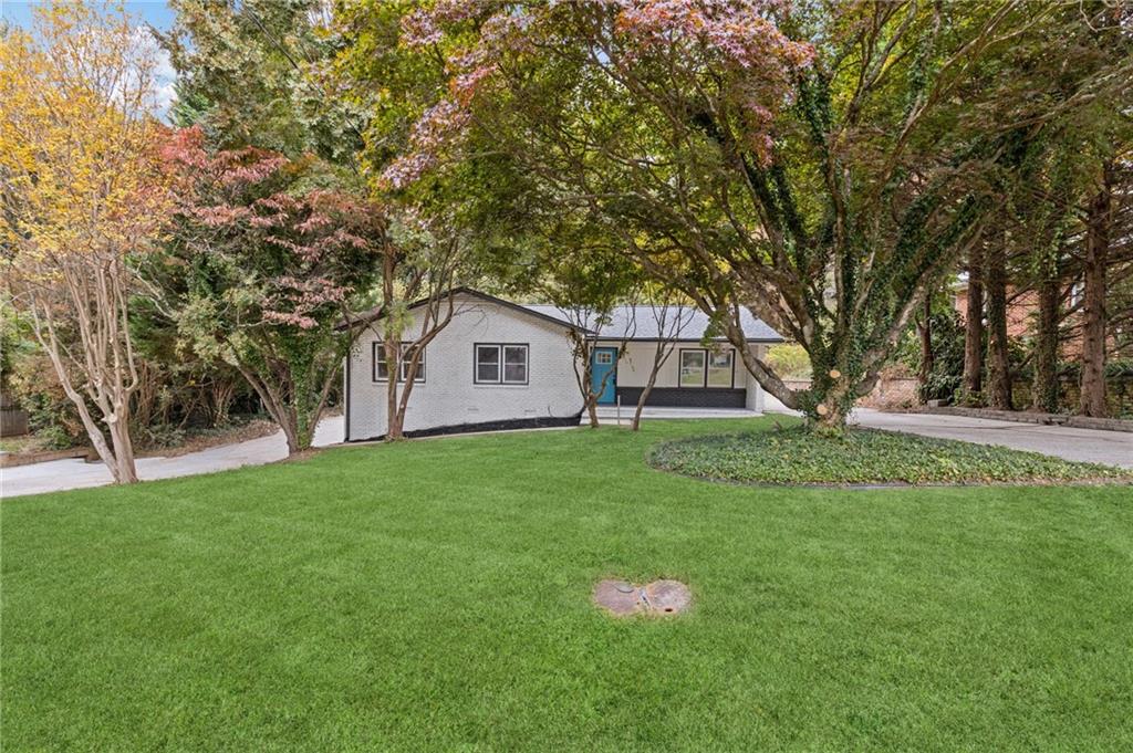 a view of a house with backyard and tree