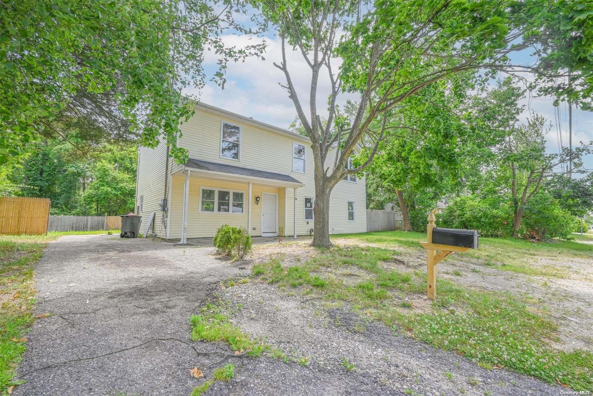 a view of a house with backyard and a tree