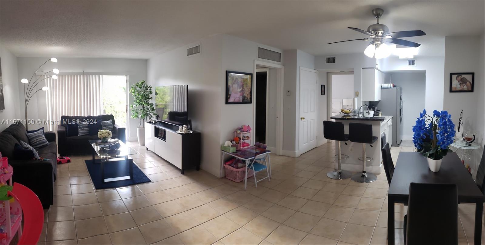 a living room with furniture a chandelier and a view of kitchen