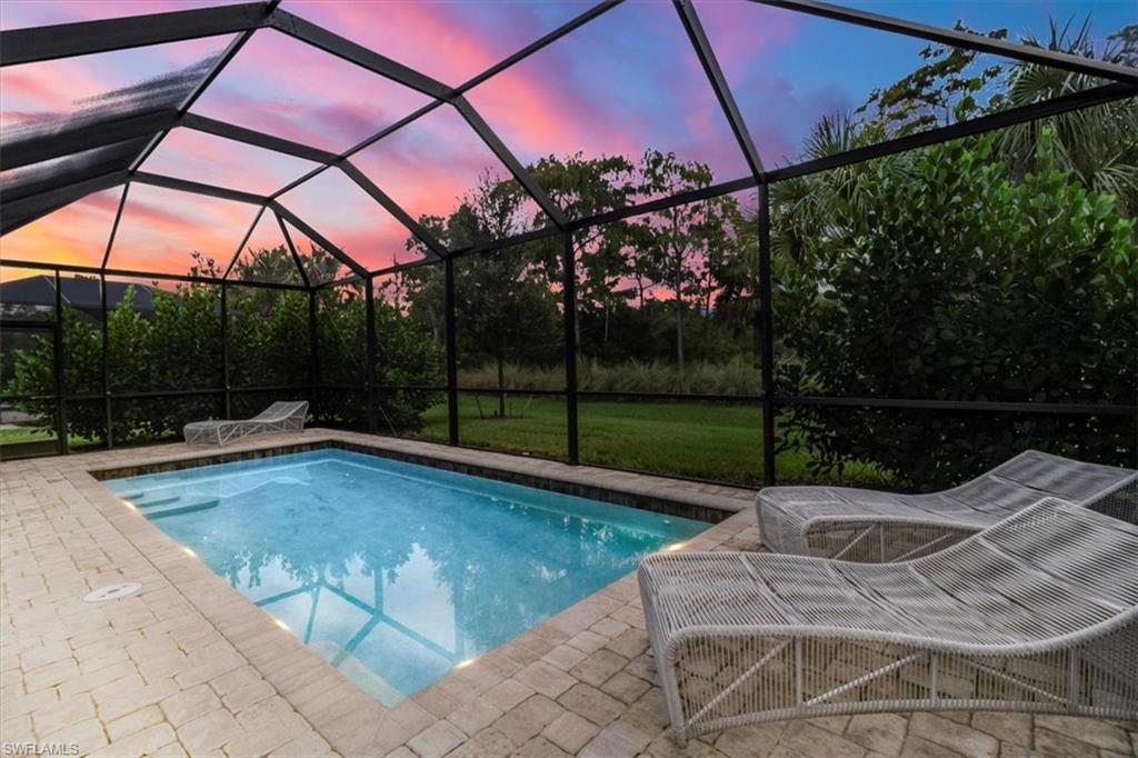 a view of backyard with swimming pool and outdoor seating