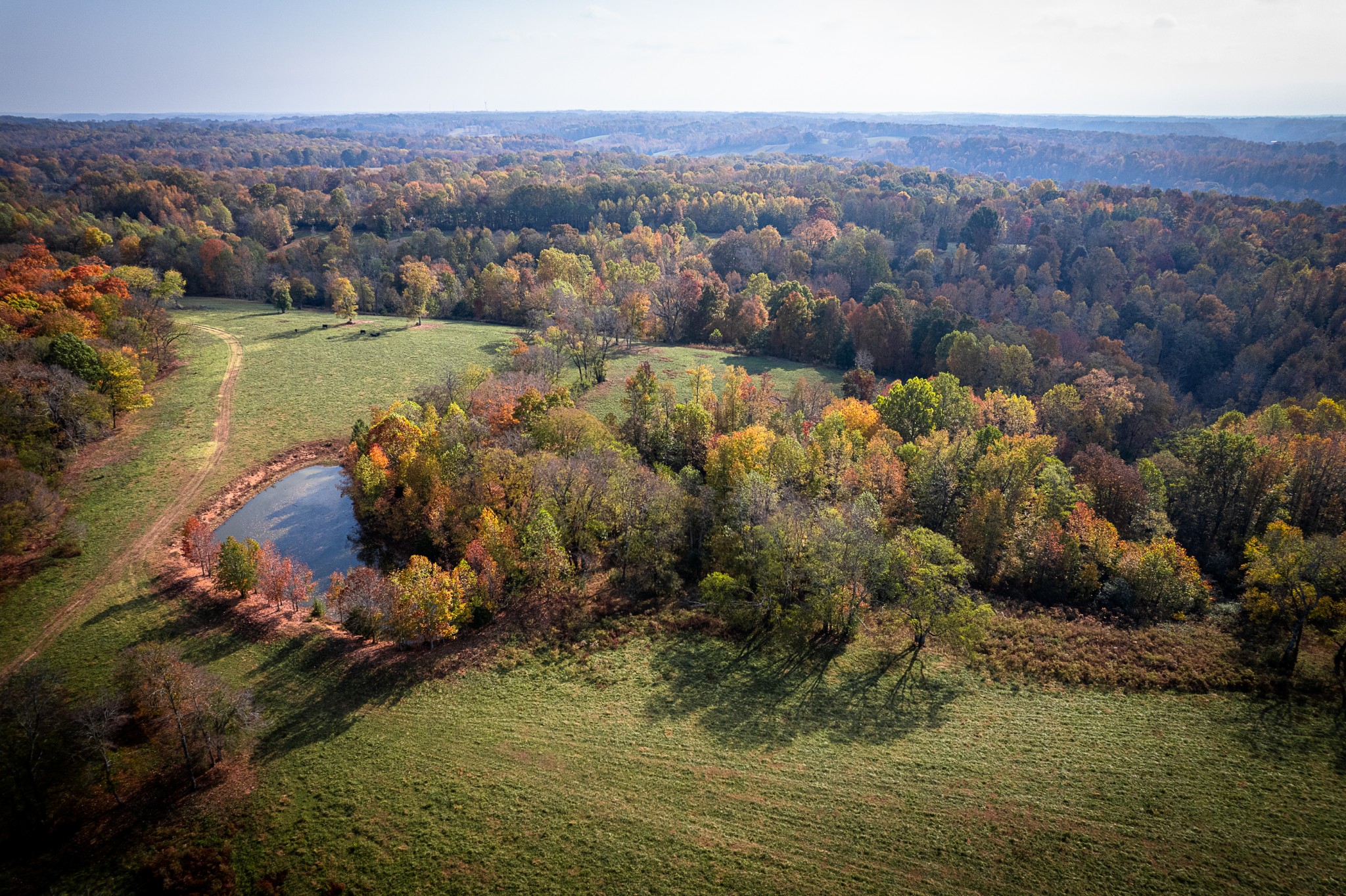 an aerial view of house with yard lake and mountain view in back