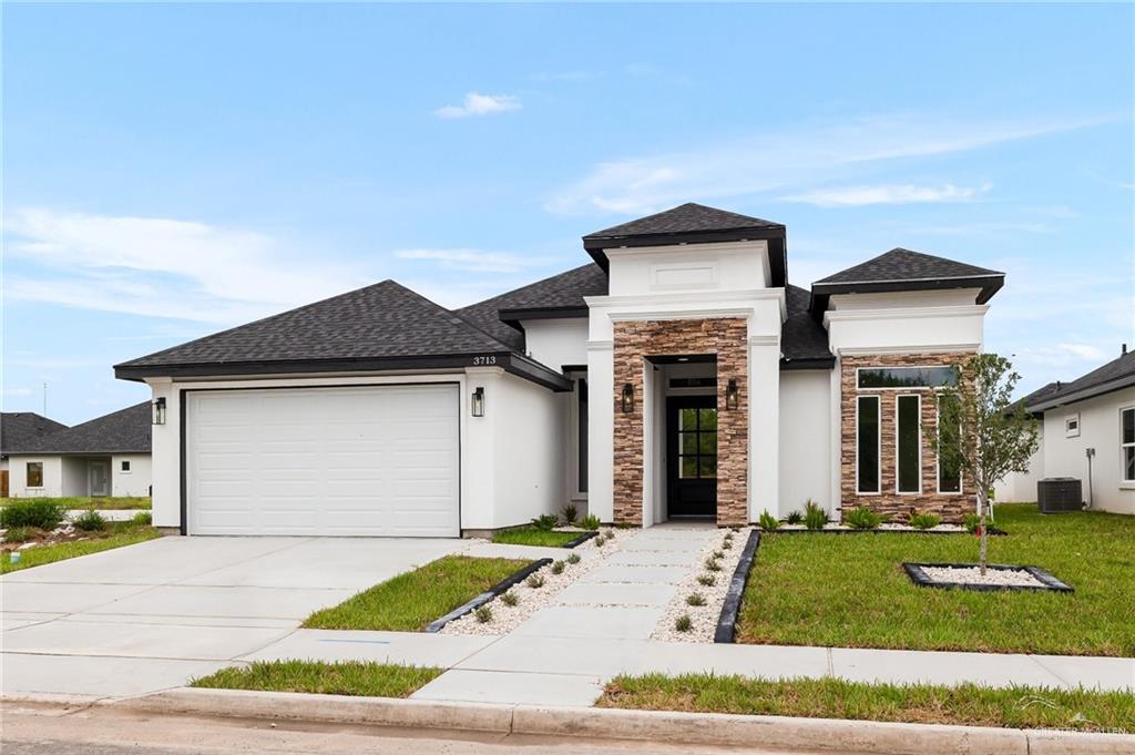 a front view of a house with a yard and garage