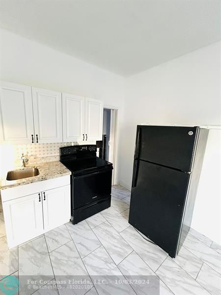 a kitchen with a sink and a refrigerator