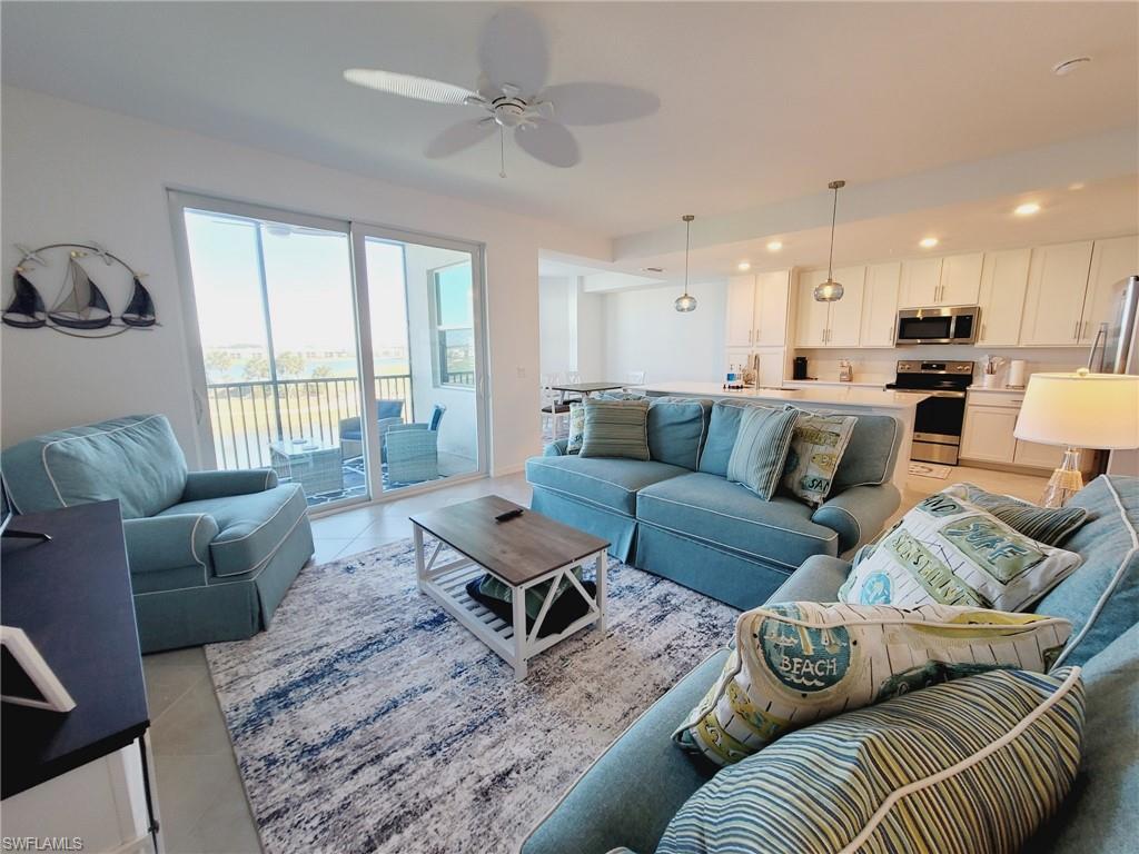 Living room featuring ceiling fan, light tile patterned floors, and sink