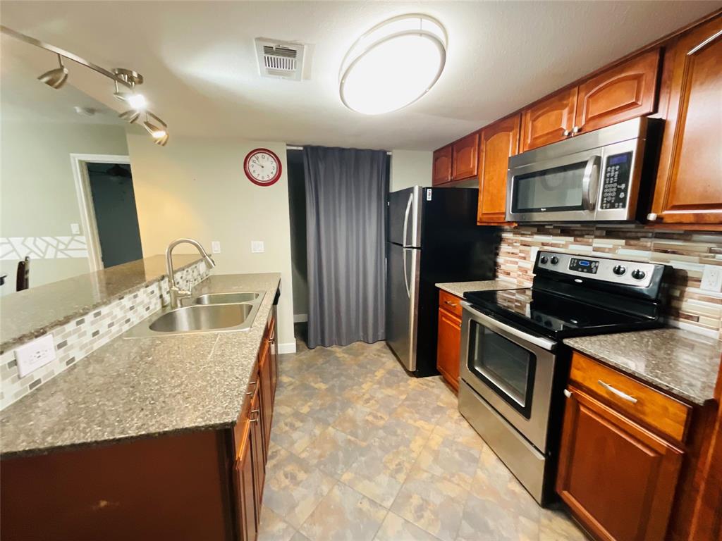 a kitchen with stainless steel appliances granite countertop a sink stove and refrigerator