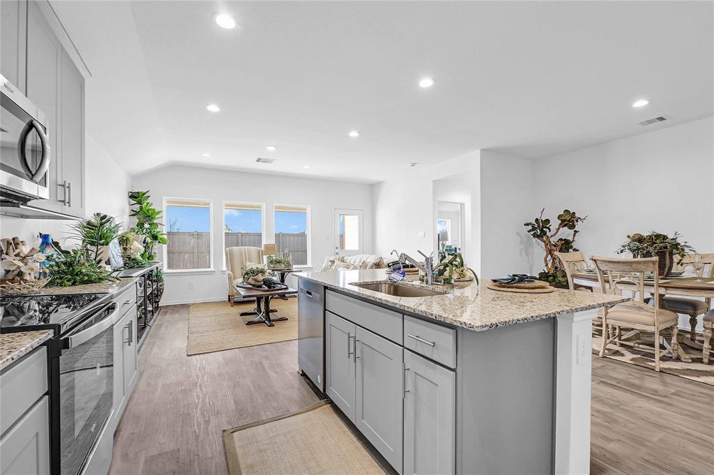 a kitchen with sink stove and cabinets