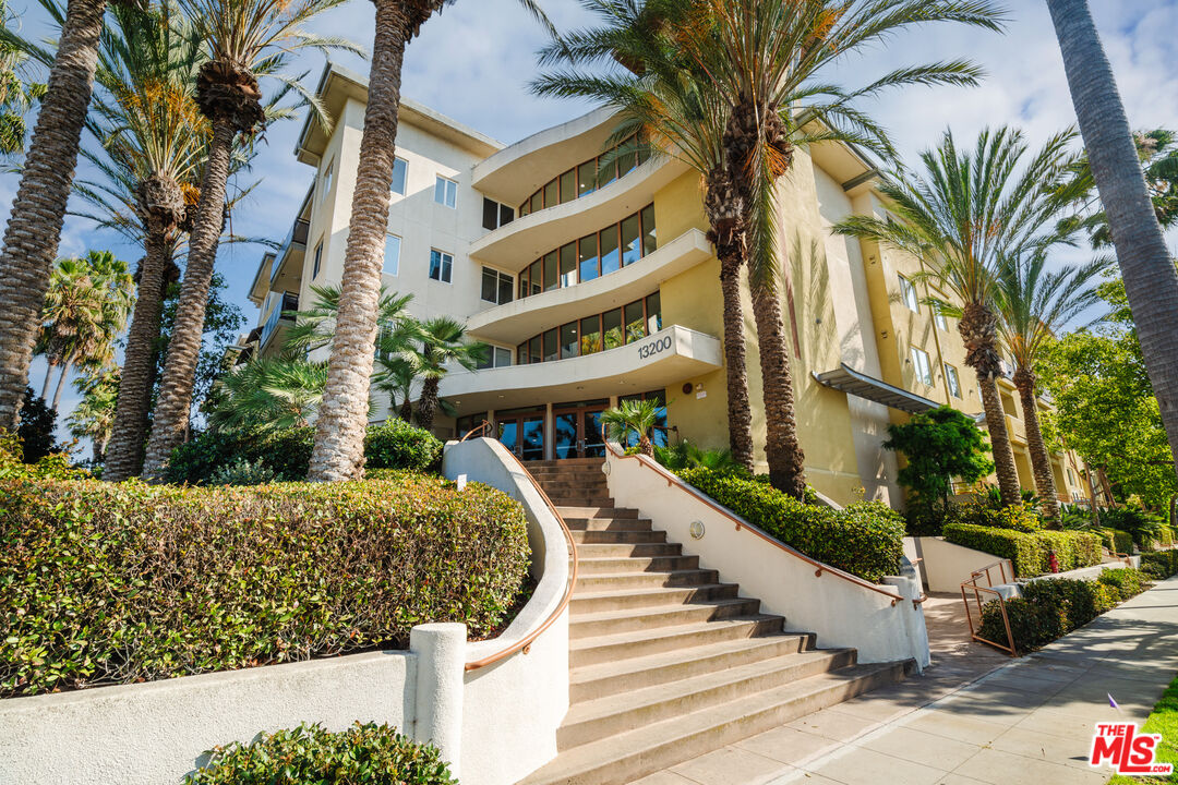 a view of a large building with swimming pool and sitting area