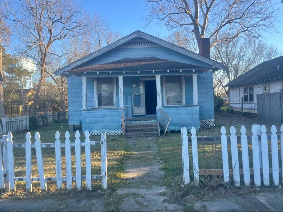 a front view of a house with wooden fence