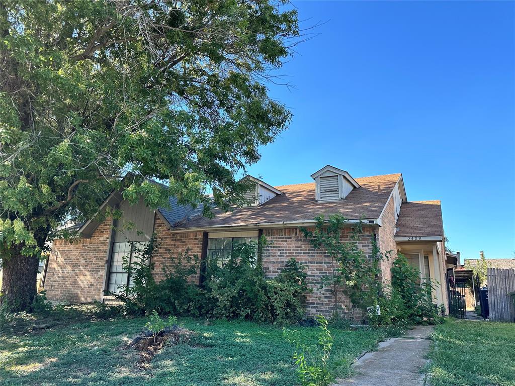 a view of a house with a tree and a yard