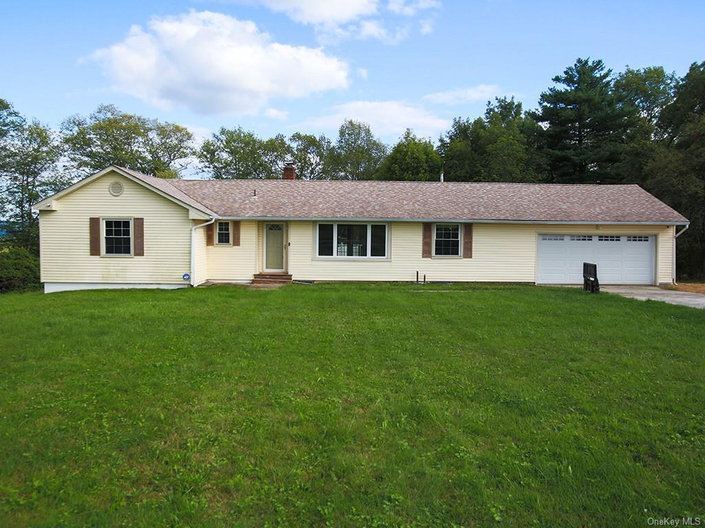 Single story home with a garage and a front yard