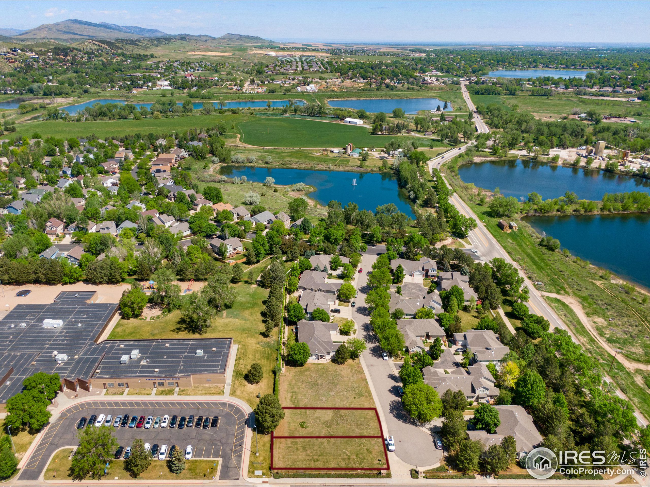 an aerial view of residential houses with outdoor space and lake view