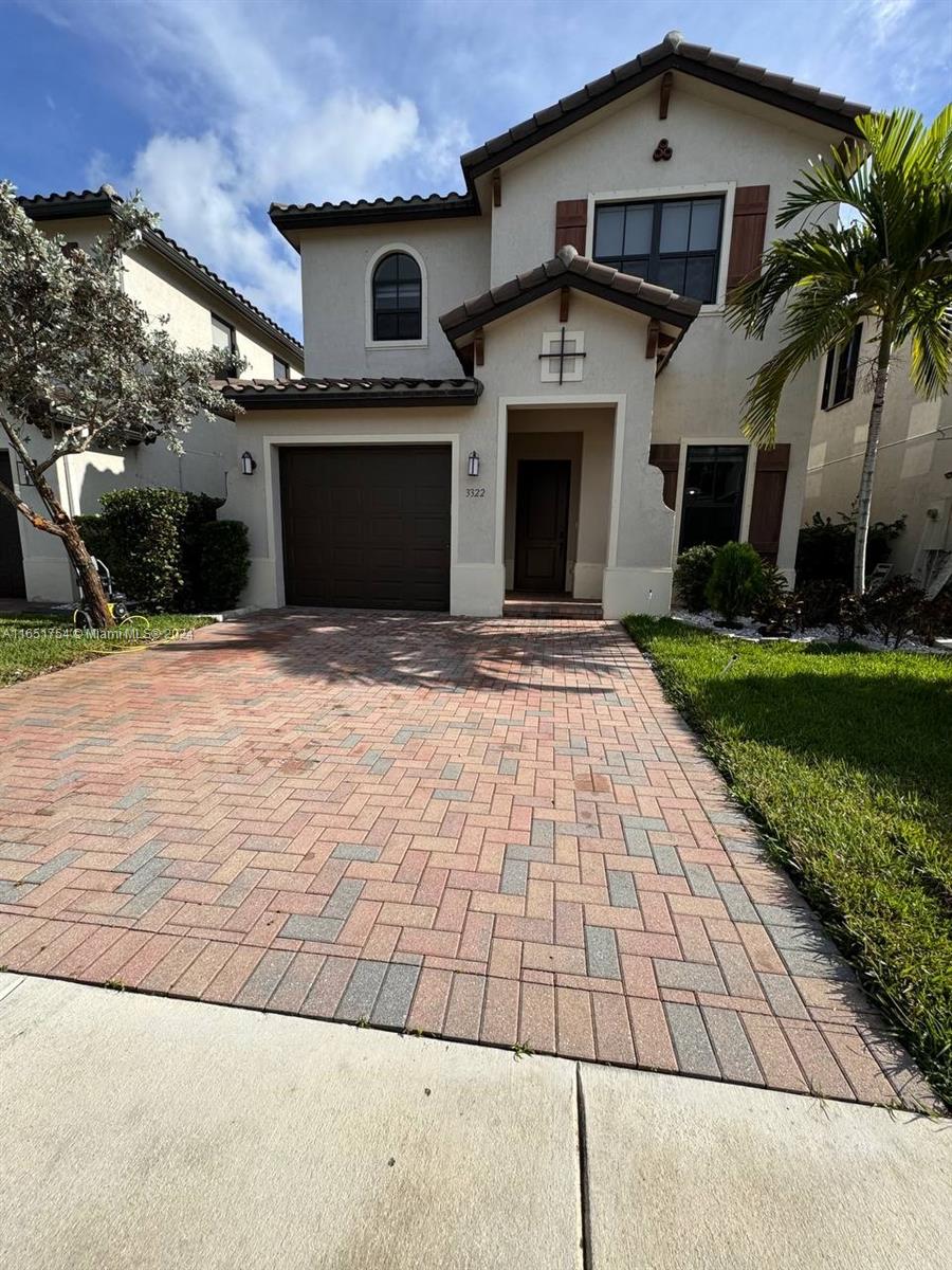 a front view of a house with a yard and a garage