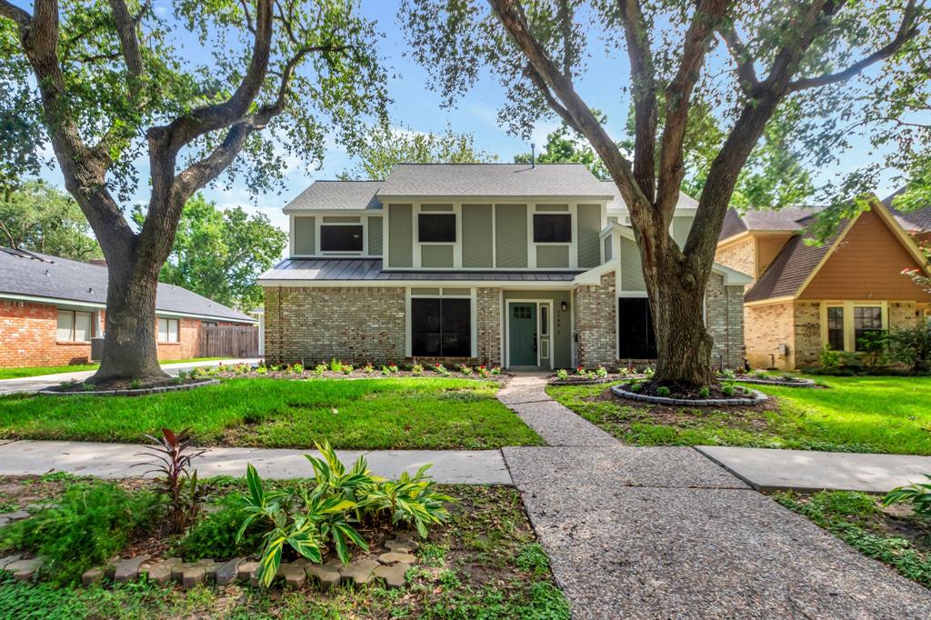 a front view of a house with a yard and trees