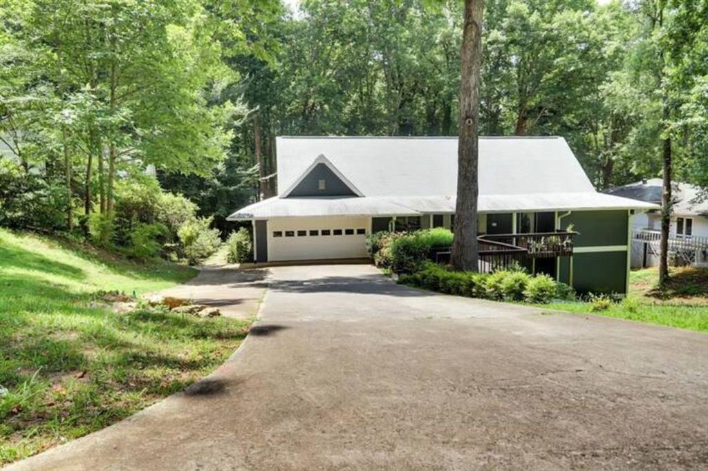 a front view of a house with a yard and trees