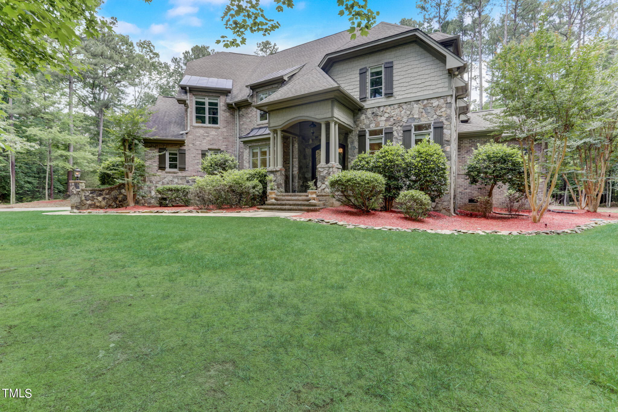 a front view of a house with a yard and trees