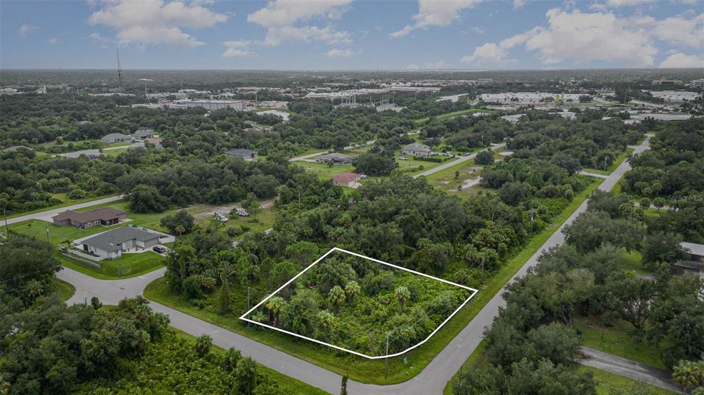 an aerial view of residential houses with outdoor space and trees