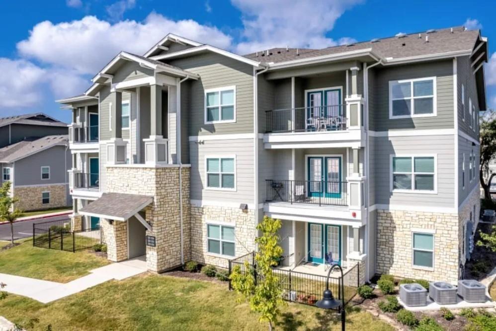 a front view of a residential apartment building with a yard