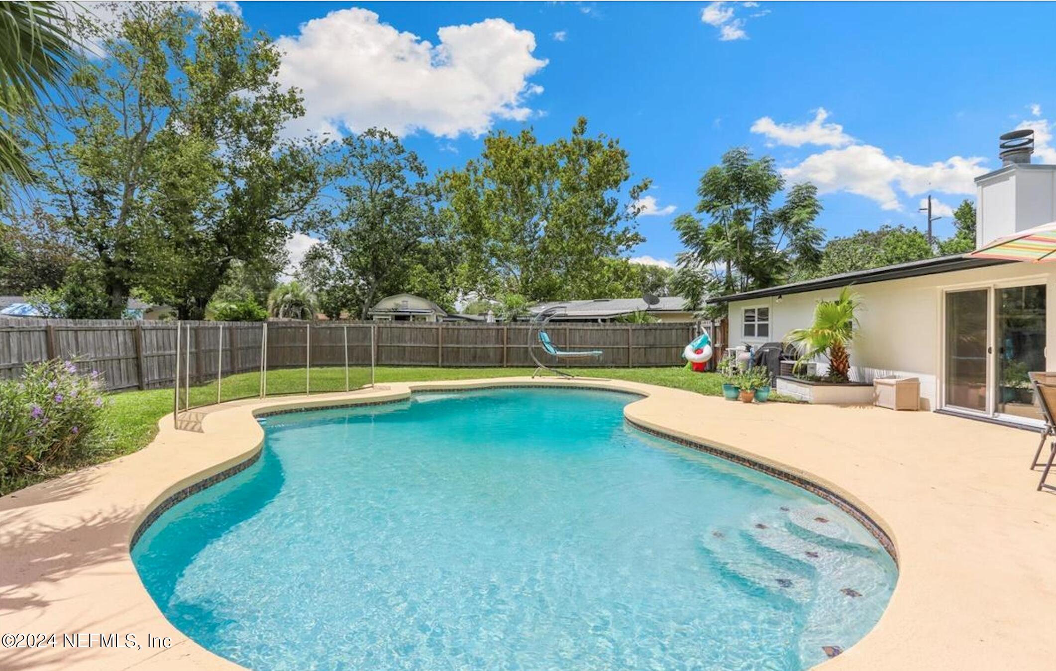 a view of a backyard with swimming pool