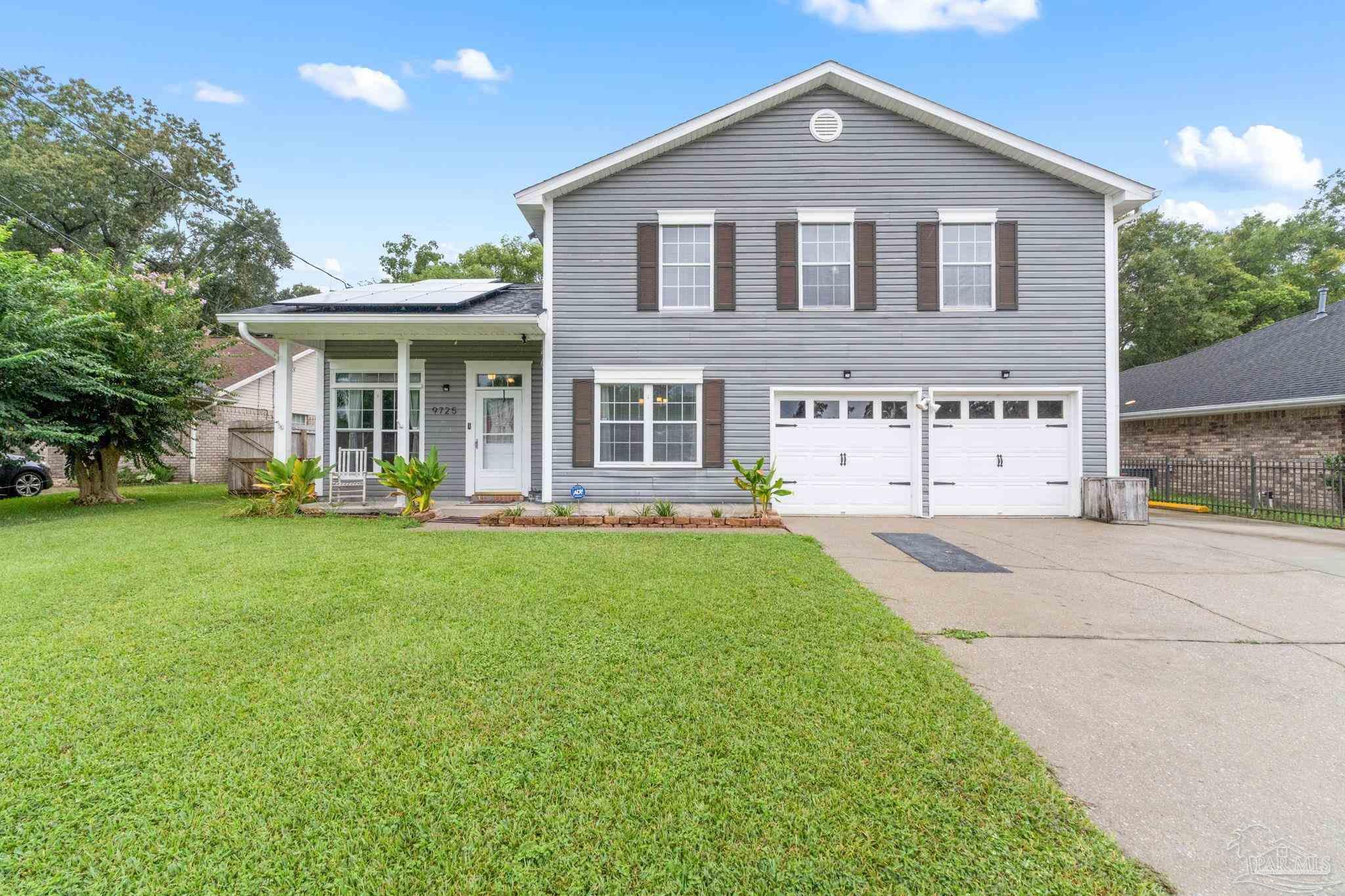 a front view of a house with a yard and trees