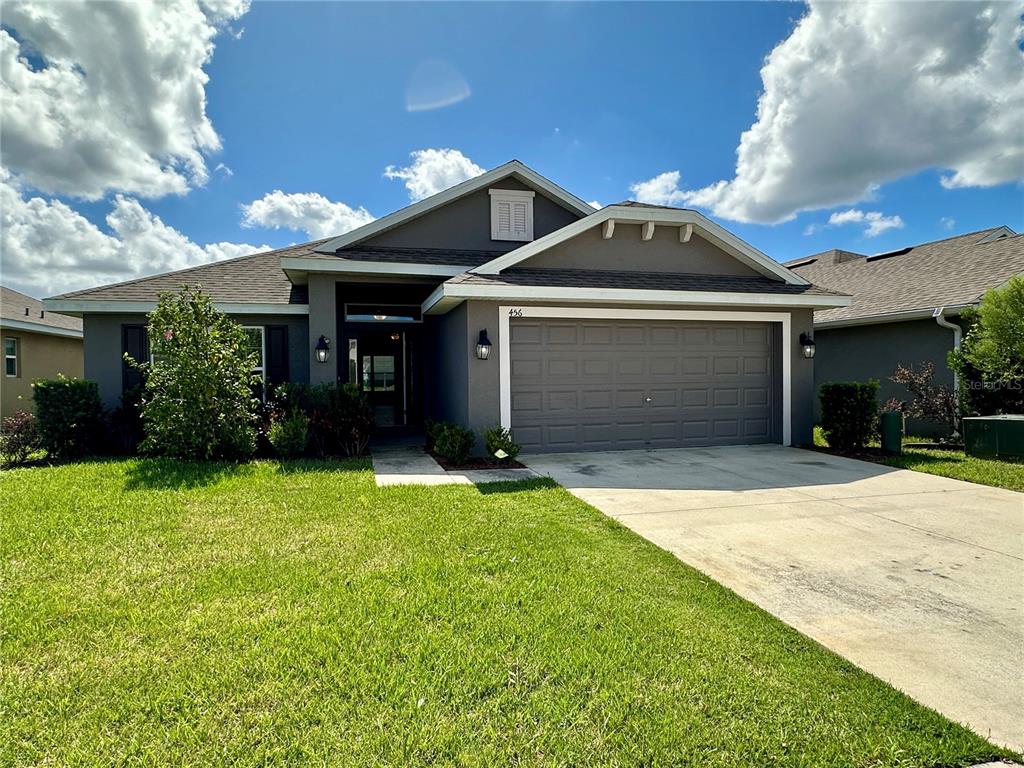 a front view of a house with a yard and garage