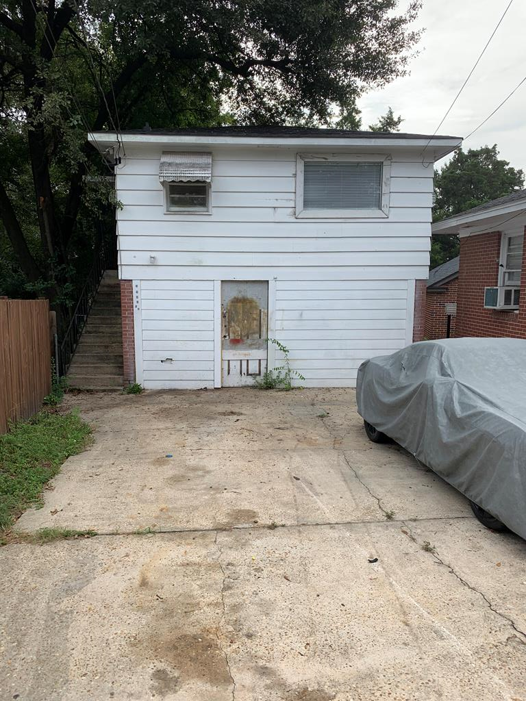 a view of backyard of house and car parked