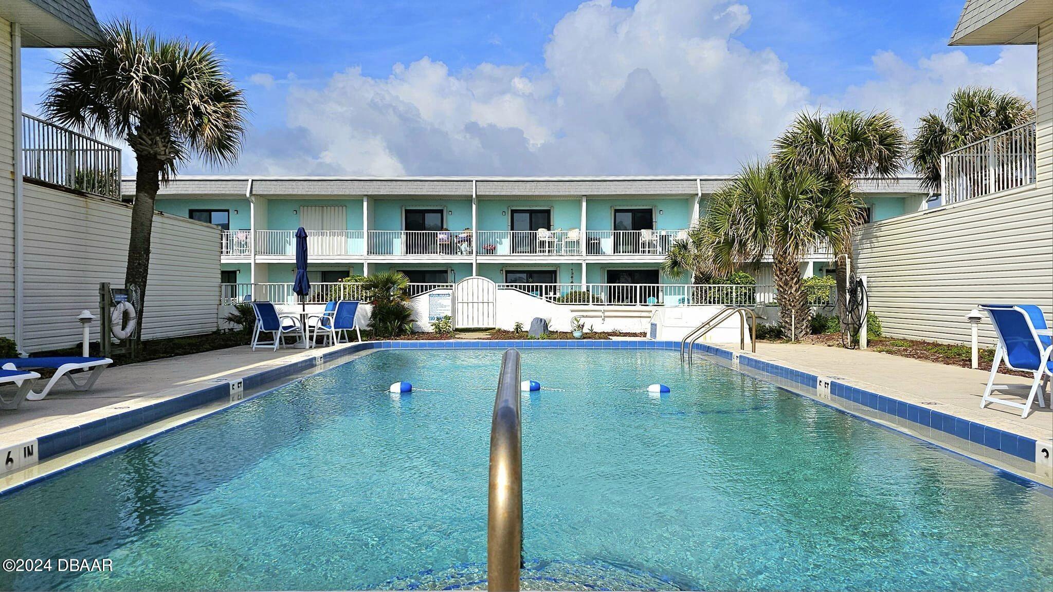 a swimming pool view with a outdoor seating