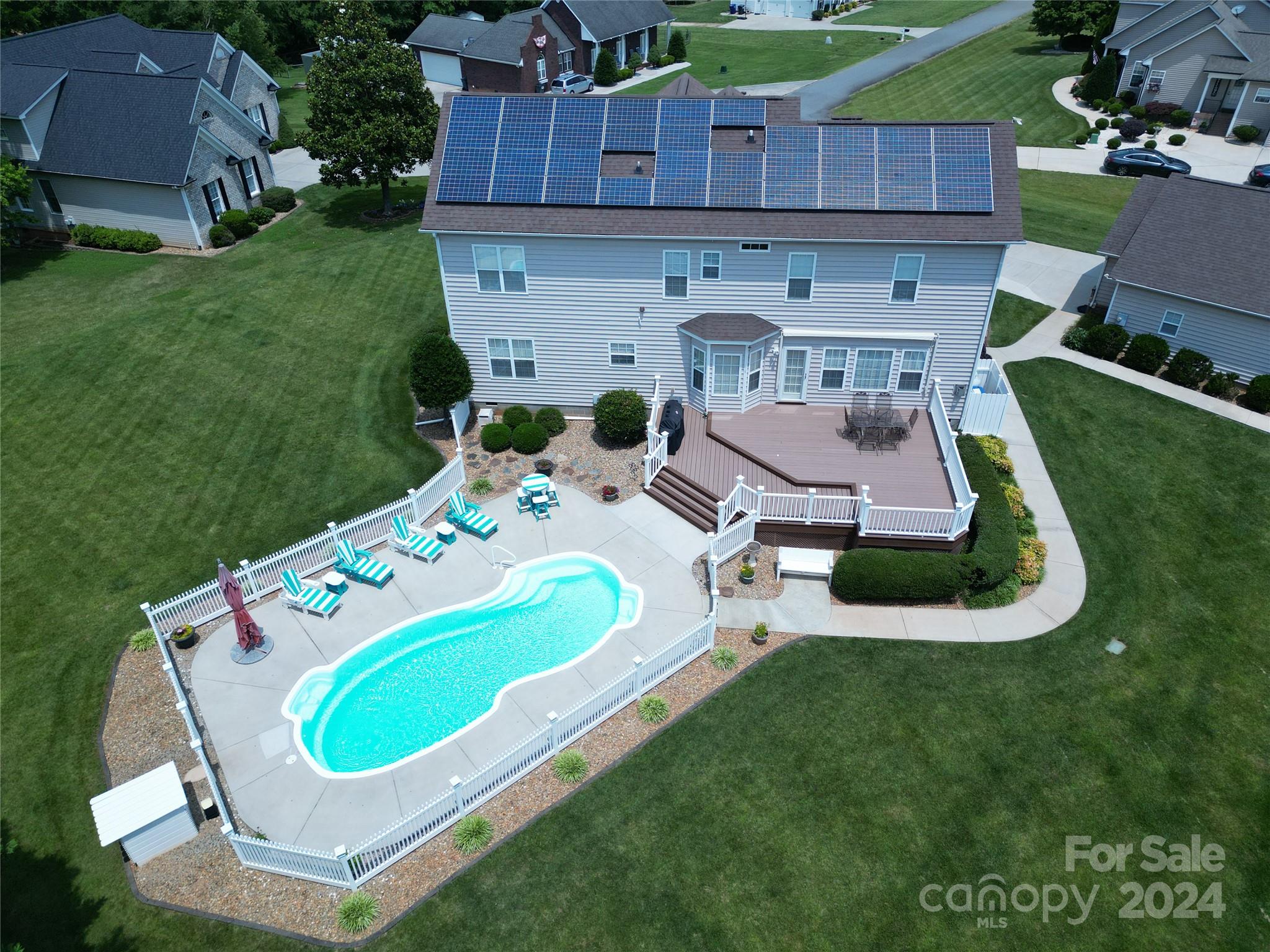 an aerial view of a house with a backyard space and sitting area