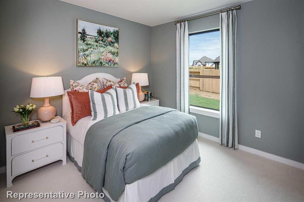 a bedroom with a bed and a lamp on dresser