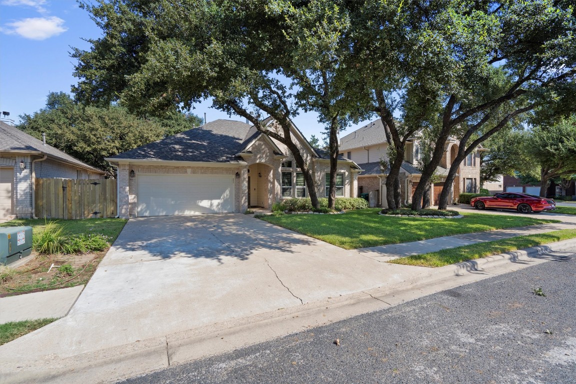 The front of the house is shaded by mature trees