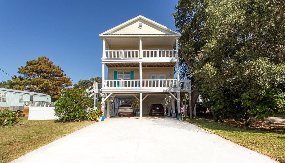 Coastal inspired home with a carport, a front yard