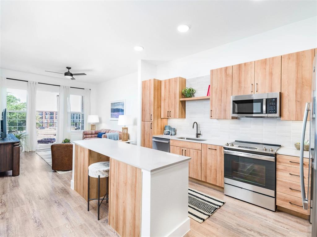 a kitchen with stainless steel appliances a stove sink and microwave