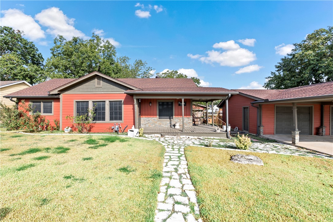 a front view of a house with a yard outdoor seating and garage