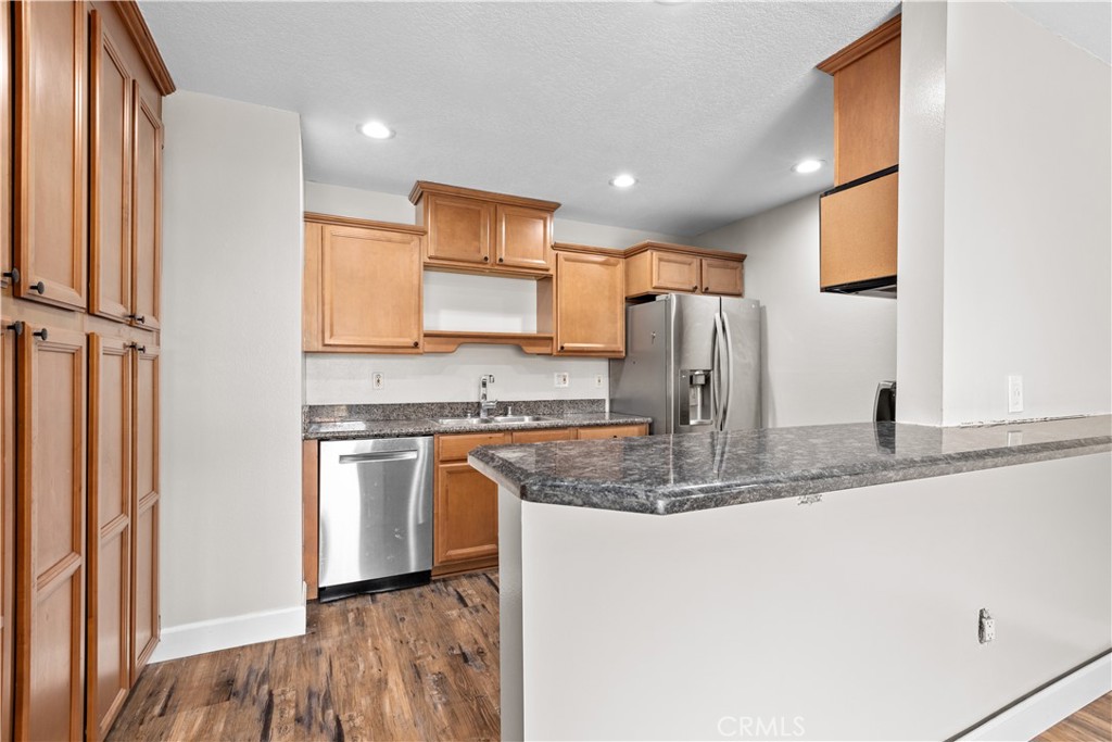 a kitchen with stainless steel appliances granite countertop a sink and a refrigerator