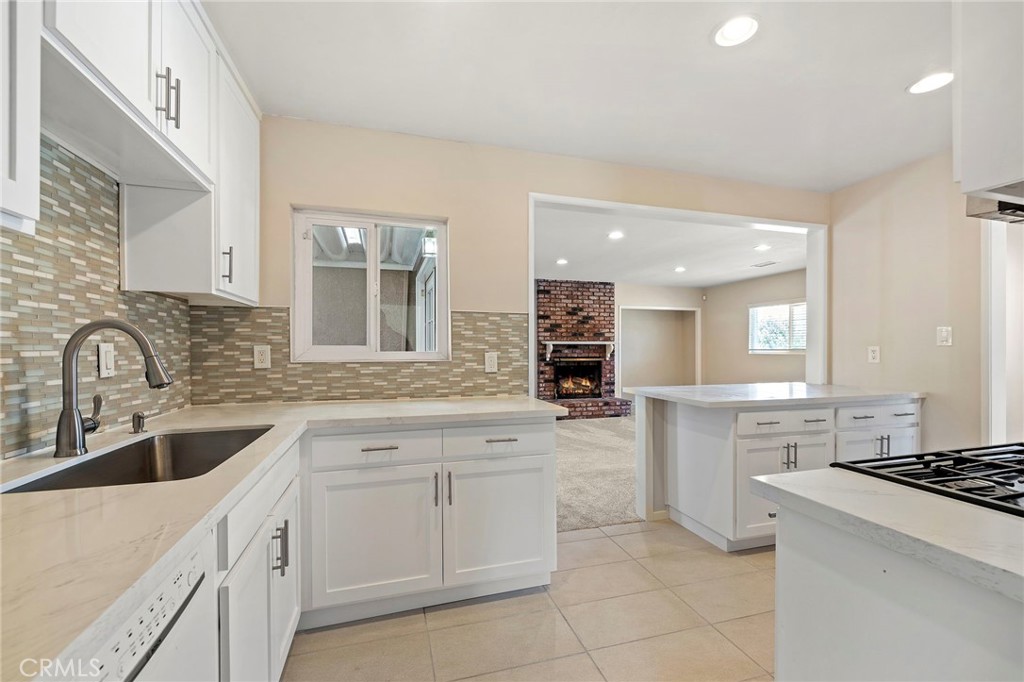 a kitchen with granite countertop a sink stove and cabinets