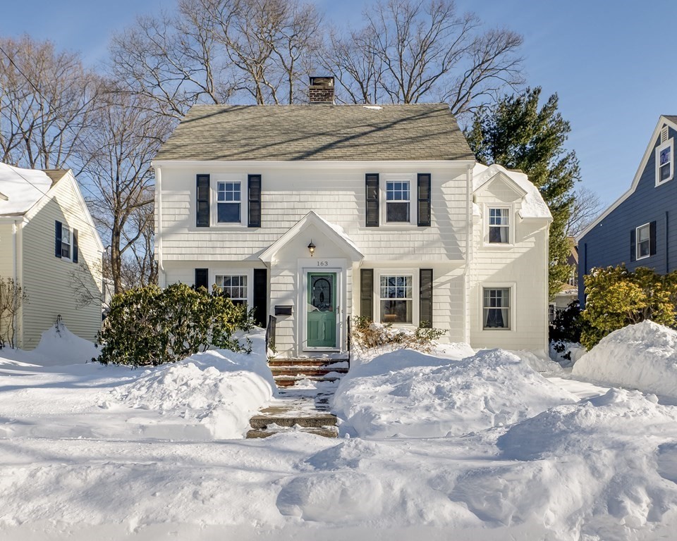 a view of a white house with a yard covered with snow in front of house