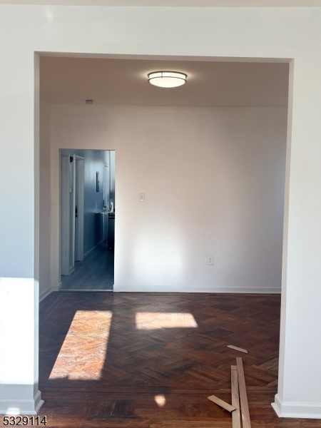 a view of a hallway with wooden floor and chair