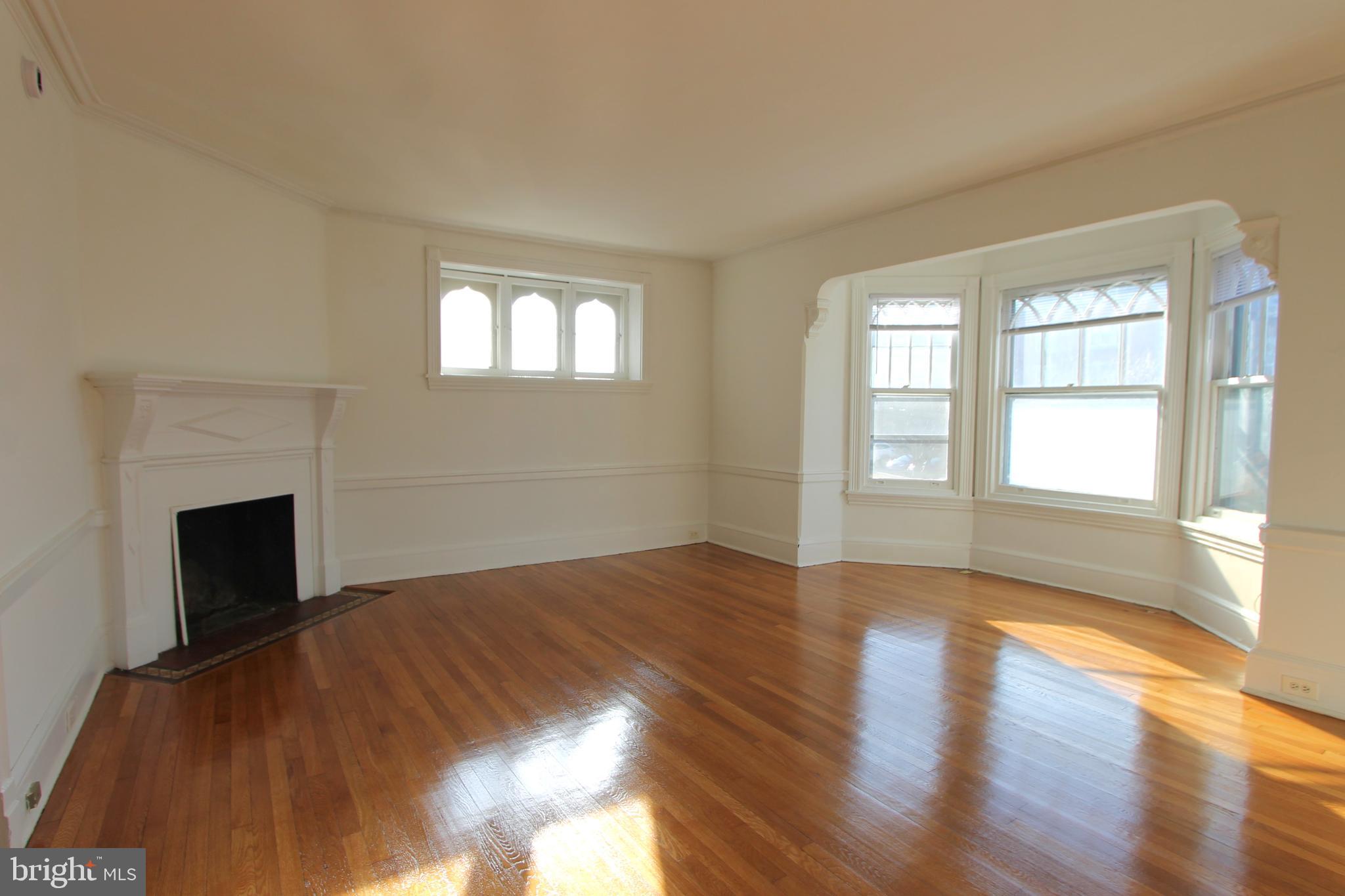 a view of empty room with wooden floor and fireplace